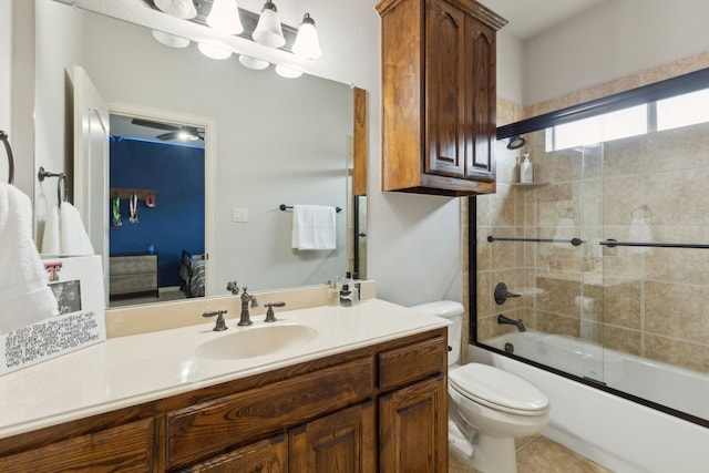 ensuite bathroom with tile patterned flooring, bath / shower combo with glass door, toilet, ensuite bathroom, and vanity