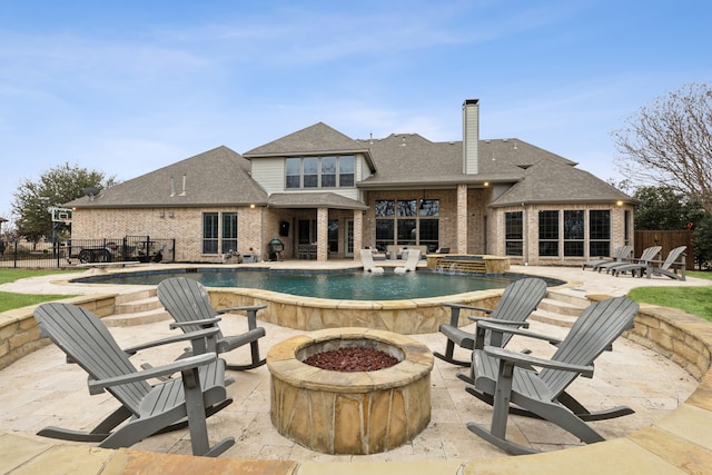 outdoor pool with a patio, fence, and an outdoor fire pit