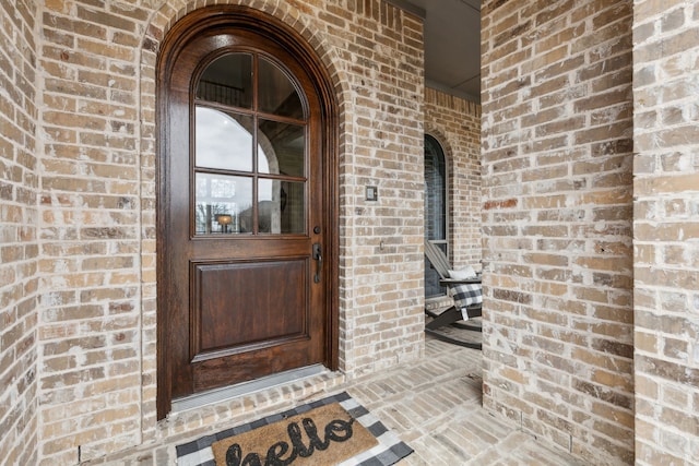 entrance to property featuring brick siding