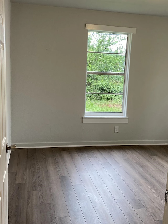 spare room with light wood-type flooring and baseboards