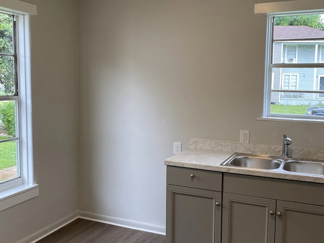 kitchen featuring light countertops, gray cabinets, a sink, and a healthy amount of sunlight