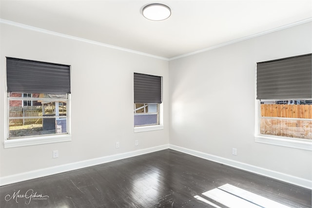 empty room with baseboards, dark wood-type flooring, and crown molding