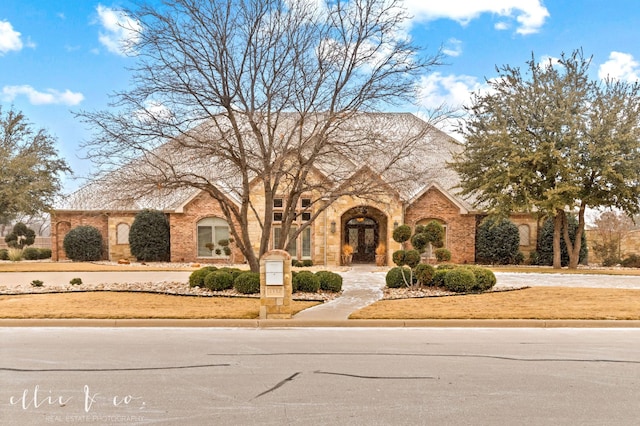 view of front facade with a front lawn and brick siding