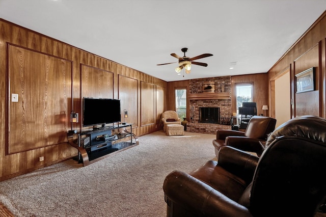 carpeted living room featuring ceiling fan, wood walls, and a brick fireplace