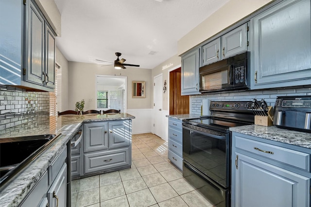 kitchen with a sink, black appliances, backsplash, and light tile patterned flooring