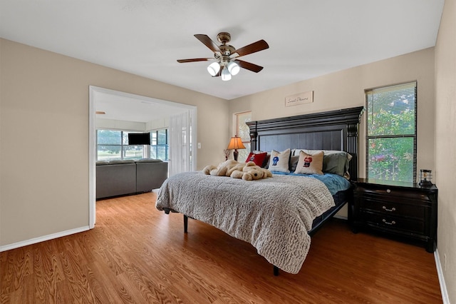 bedroom featuring ceiling fan, wood finished floors, and baseboards