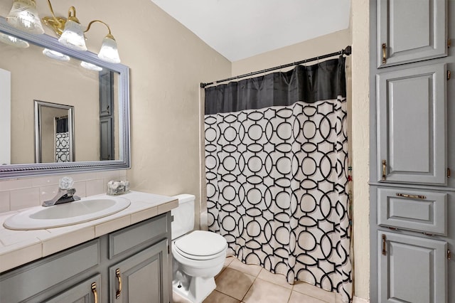 bathroom featuring tasteful backsplash, a shower with shower curtain, toilet, tile patterned flooring, and vanity