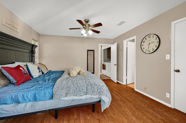 bedroom with washer and clothes dryer, visible vents, ceiling fan, wood finished floors, and baseboards