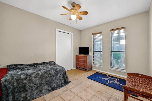 bedroom with a ceiling fan, a closet, and light tile patterned floors