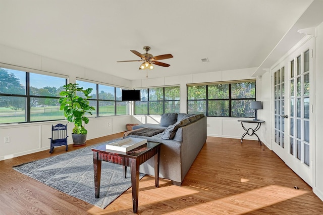 sunroom / solarium featuring french doors, visible vents, and a ceiling fan