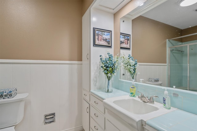 bathroom featuring visible vents, toilet, a wainscoted wall, vanity, and a shower stall