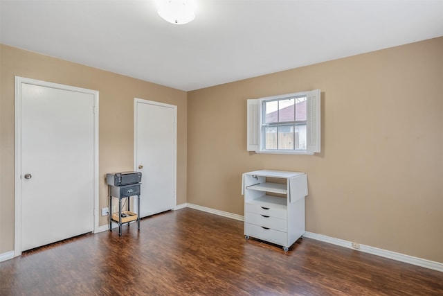 bedroom with dark wood-style floors and baseboards