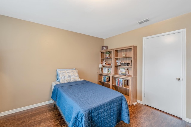 bedroom with dark wood-style flooring, visible vents, and baseboards