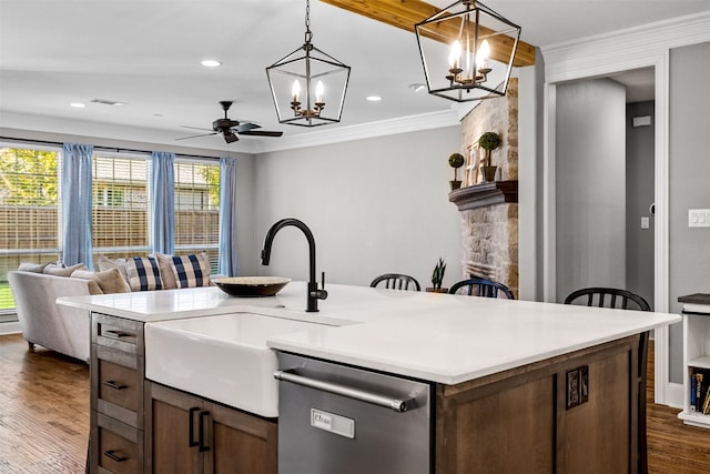 kitchen featuring light countertops, open floor plan, a sink, an island with sink, and dishwasher