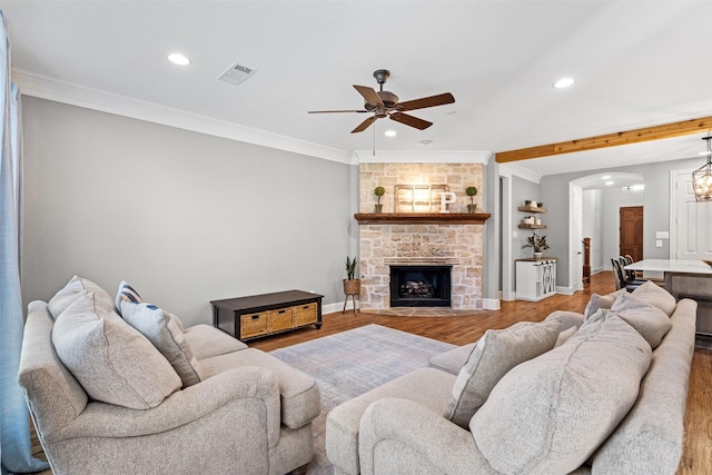 living area with recessed lighting, a fireplace, wood finished floors, visible vents, and crown molding