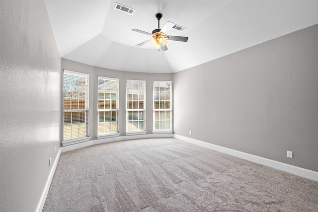 carpeted spare room with visible vents, a textured wall, vaulted ceiling, ceiling fan, and baseboards