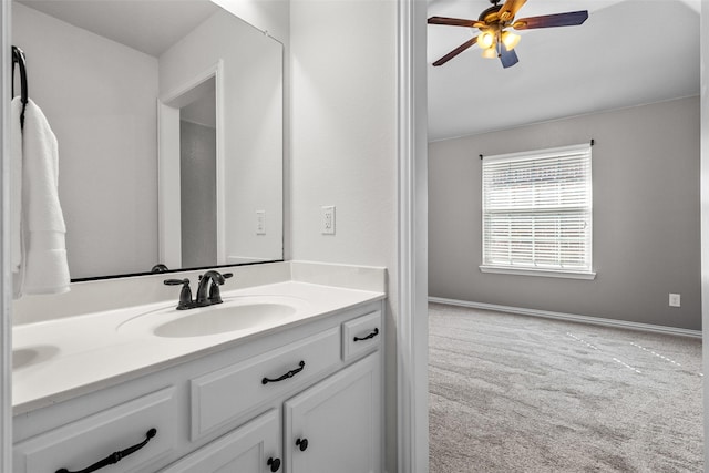 bathroom featuring ceiling fan, baseboards, and vanity