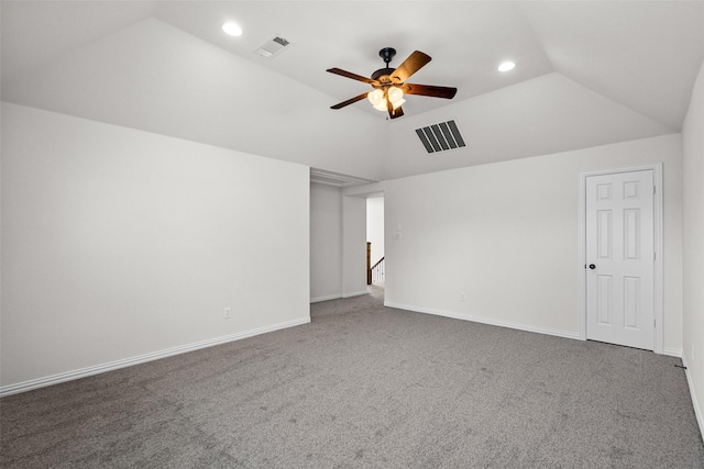 spare room with lofted ceiling, visible vents, and dark carpet