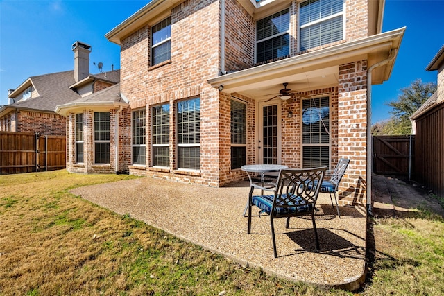 back of house featuring a patio area, a fenced backyard, a ceiling fan, and brick siding