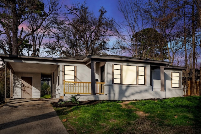 mid-century inspired home with driveway, covered porch, a front lawn, and brick siding