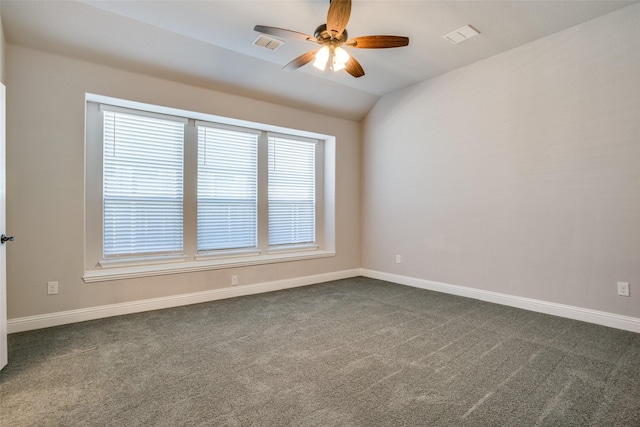 spare room with lofted ceiling, baseboards, and dark colored carpet