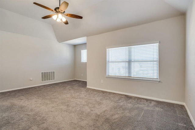 empty room with baseboards, visible vents, a ceiling fan, lofted ceiling, and carpet floors