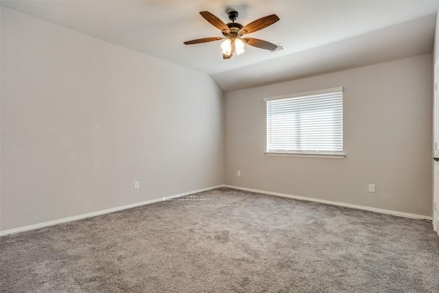 carpeted spare room featuring ceiling fan, baseboards, and vaulted ceiling