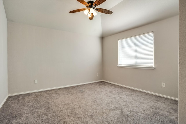 carpeted empty room featuring lofted ceiling, ceiling fan, and baseboards