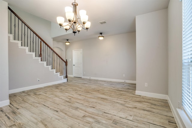 interior space featuring light wood-type flooring, stairway, baseboards, and visible vents