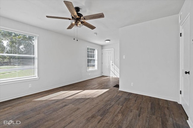 spare room with dark wood-type flooring, baseboards, and a ceiling fan