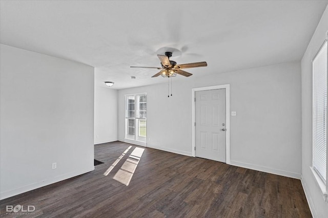 unfurnished room featuring dark wood finished floors, baseboards, and ceiling fan