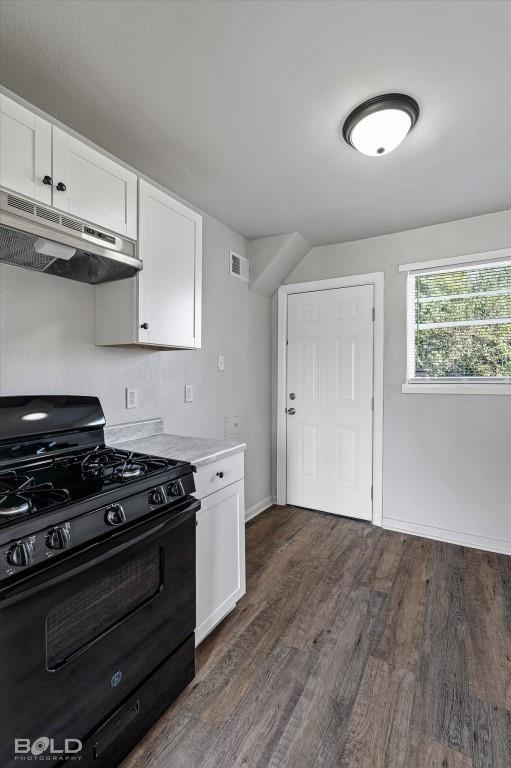 kitchen with white cabinets, under cabinet range hood, black range with gas stovetop, and light countertops