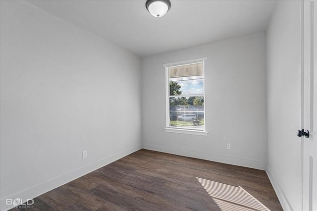 empty room featuring dark wood-style floors and baseboards