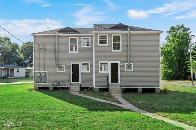 back of property featuring entry steps and a yard