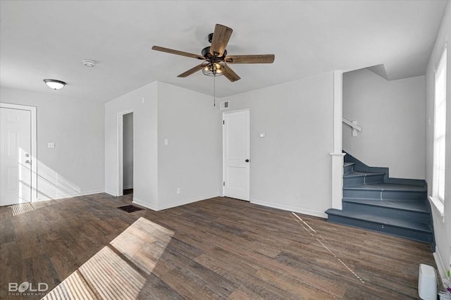 unfurnished living room featuring stairs, dark wood-style flooring, visible vents, and baseboards