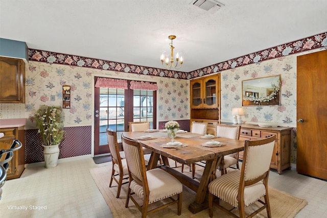 735 State Highway 37 N, Clarksville, TX 75426 - dining area featuring visible vents, wallpapered walls, a chandelier, and light floors