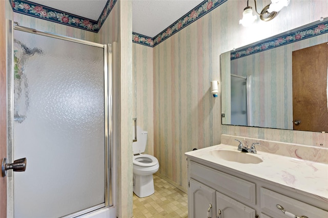 bathroom with wallpapered walls, toilet, a textured ceiling, vanity, and a shower stall