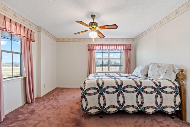 bedroom with a textured ceiling, multiple windows, and carpet