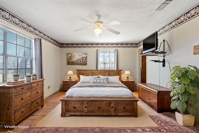735 State Highway 37 N, Clarksville, TX 75426 - bedroom featuring a textured ceiling, visible vents, a ceiling fan, and wood finished floors