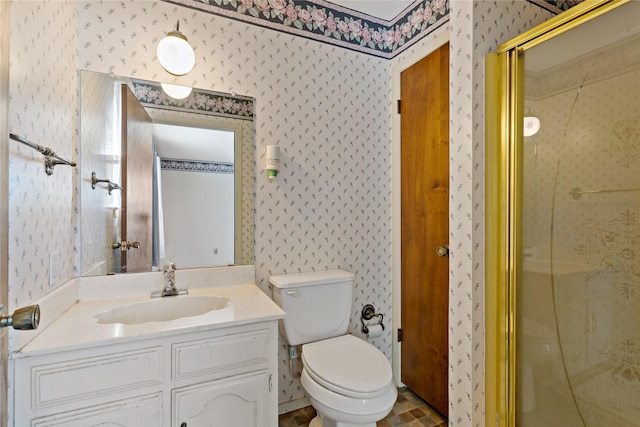 bathroom with a stall shower, vanity, toilet, and wallpapered walls