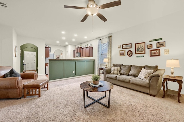 living area with arched walkways, recessed lighting, light colored carpet, a ceiling fan, and visible vents