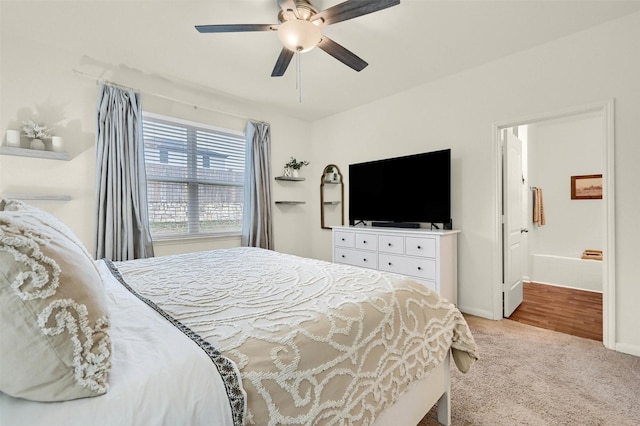 bedroom featuring a ceiling fan, light carpet, connected bathroom, and baseboards