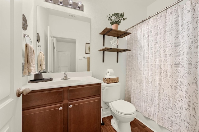 bathroom with toilet, wood finished floors, and vanity