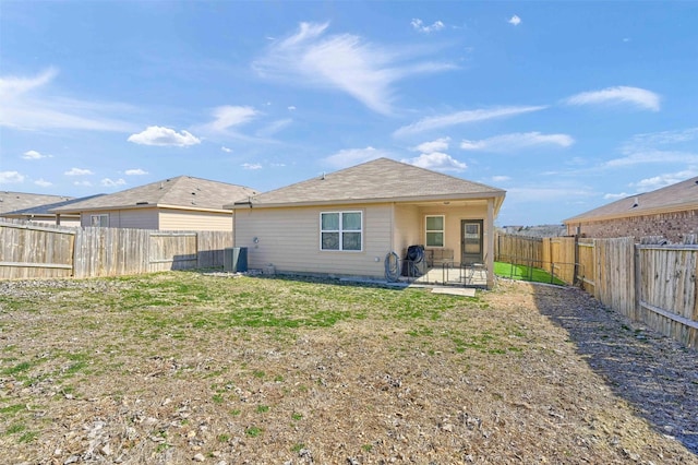 back of property with a lawn, a patio area, and a fenced backyard