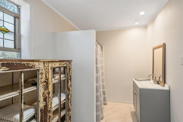 bathroom with baseboards, ornamental molding, vanity, and recessed lighting