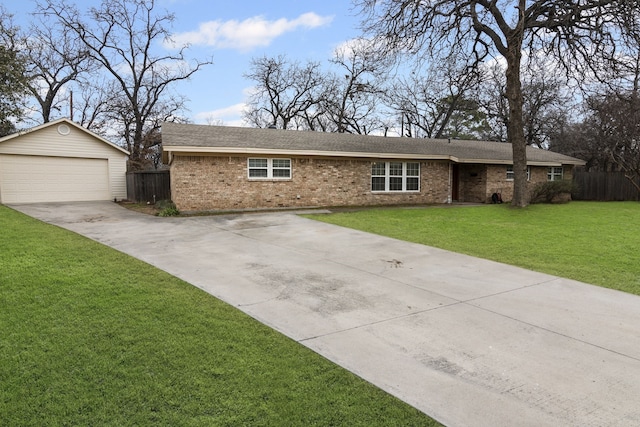 ranch-style home featuring an outbuilding, brick siding, a detached garage, and a front yard