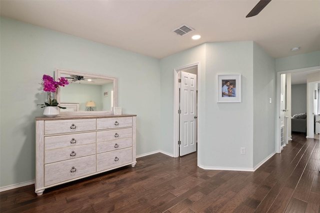 unfurnished bedroom with dark wood-style floors, visible vents, ceiling fan, and baseboards