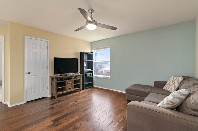 living room with baseboards, a ceiling fan, and dark wood-style flooring