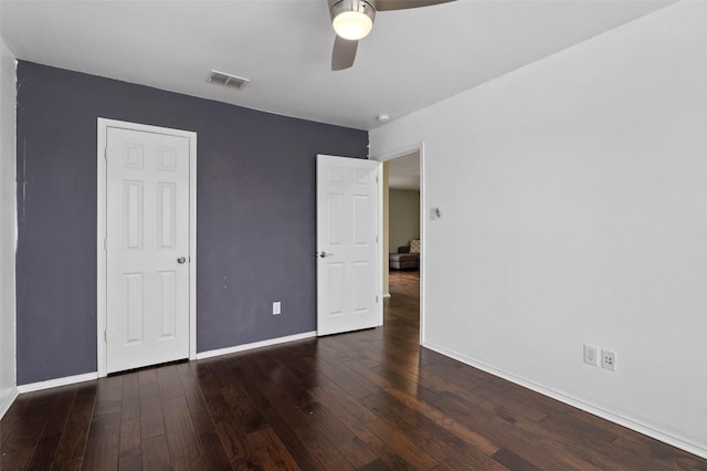 unfurnished bedroom with baseboards, visible vents, ceiling fan, and dark wood-type flooring