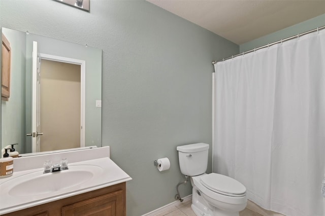 bathroom featuring baseboards, vanity, toilet, and tile patterned floors